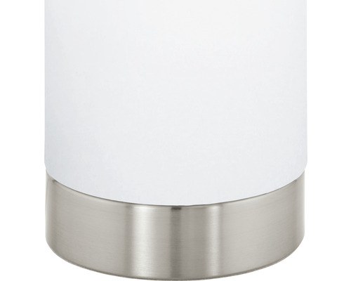 Detalj av en vit bordslampa med metallfot