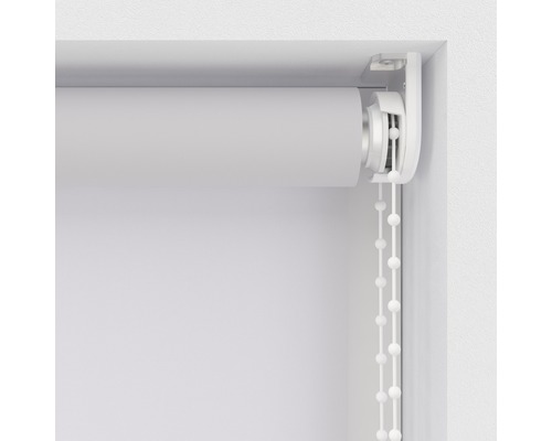 Detaljvy av en vit rullgardin med kedjedrift vid fönstret