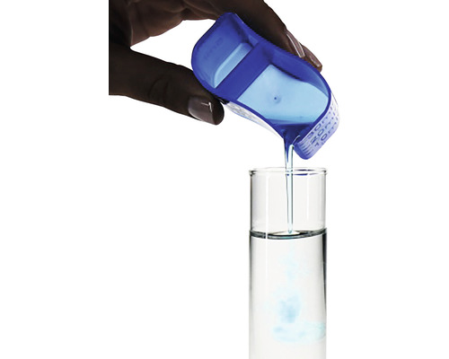 En vätska hälls i ett provrör med en blå mätkopp.