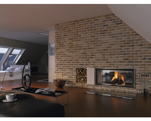 Vardagsrum med murad vägg, öppen spis, vedförvaring och vardagsrumsmöbler.