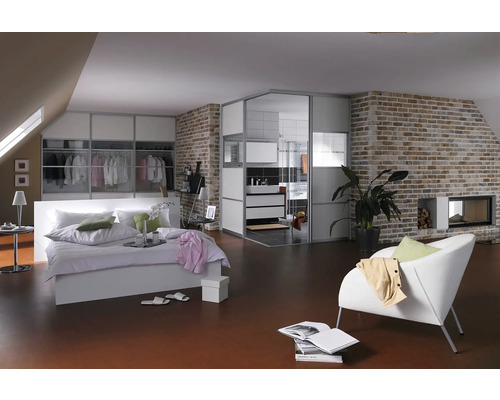 Ljust sovrum med säng, garderob, badrum och tegelvägg