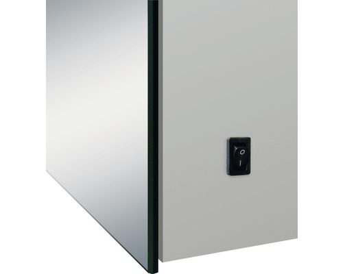 Detaljvy av ett spegelskåp med strömbrytare