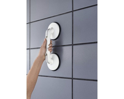 Hand som håller ett sugkoppshandtag på väggen