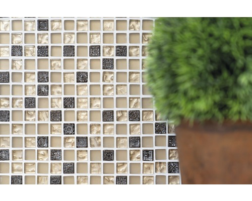 Kakelvägg med mosaik, kvadratiska plattor och krukväxt