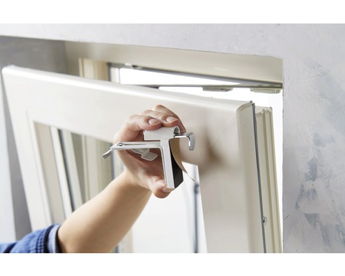 Person monterar ett fönster med fästklämma