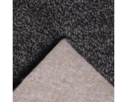 Detaljvy av en mörkgrå matta med textilbaksida