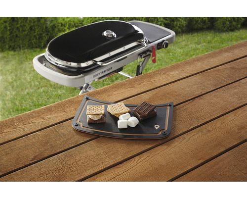 Weber Traveler-grill och S''mores-ingredienser på en serveringsbräda på ett träbord