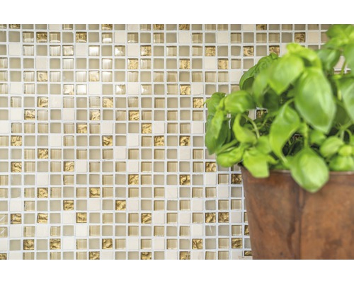 Mosaikplattvägg med basilikaväxt i kruka