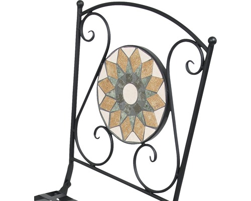 Detaljvy av en trädgårdsstol med mosaikmönster i ryggstödet och metallram.