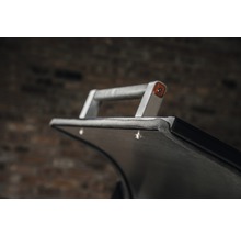 Detaljvy av en transportvagn med handtag och reflektor.
