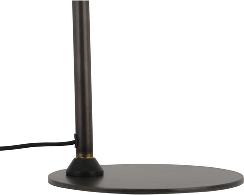 Detaljvy av en golvlampa med metallfot och strömkabel