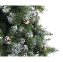 Detaljvy av en konstgjord julgran med kottar och frostiga spetsar