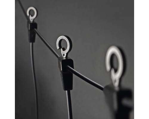 Närbild av en ljusslinga med fästklämmor och krokar för montering