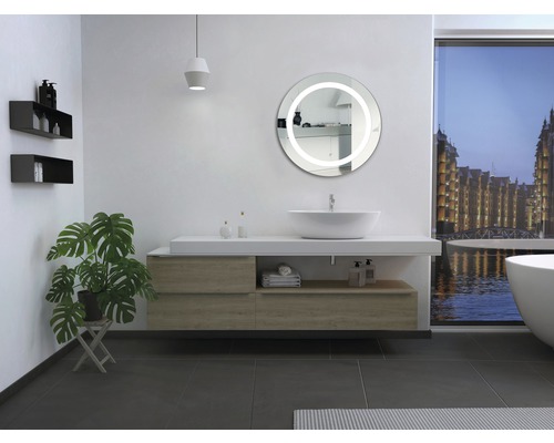 Modernt badrum med tvättställ, spegel med belysning och växt