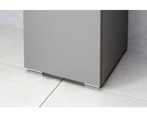 Detaljvy av ett badrumsskåp på ett klinkergolv