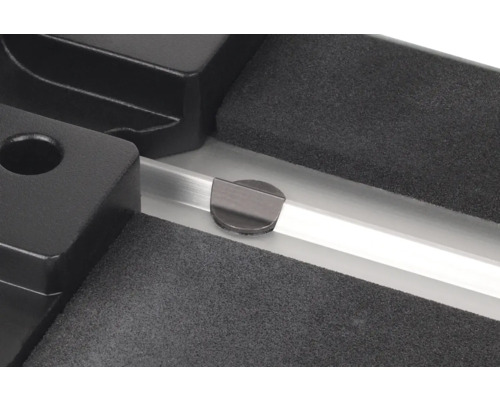 Detaljvy av en arbetsbänk med spännanordning och metallskena