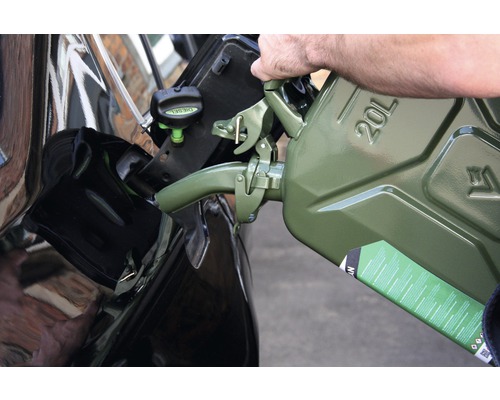En person fyller diesel från en 20 liters reservdunk i en bil.