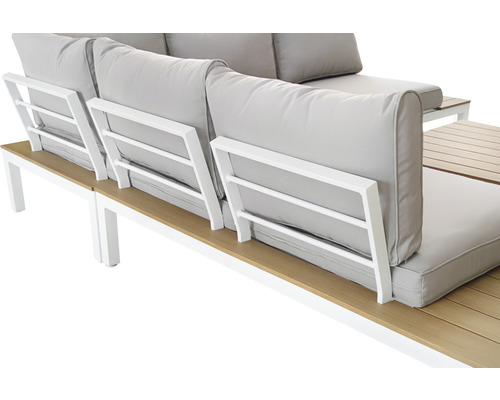 Detaljvy av en loungeset med ljusa dynor och ett bord med trälameller