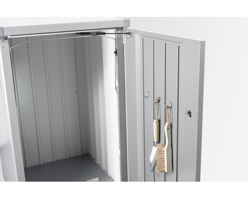 Öppet redskapsskåp i metall med trädgårdsredskap på insidan av dörren