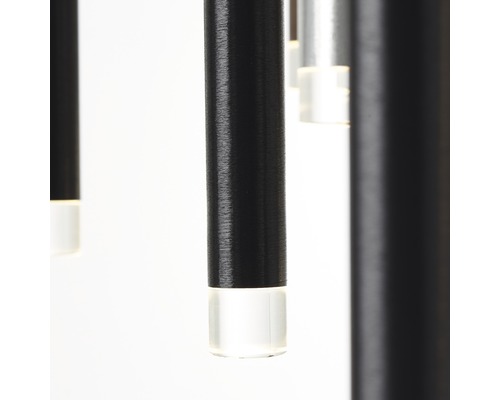 Detaljbild av en pendellampa med cylindriska, svarta element och klara avslut