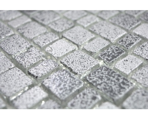 Närbild av glasmosaikplattor med silverfärgad yta.