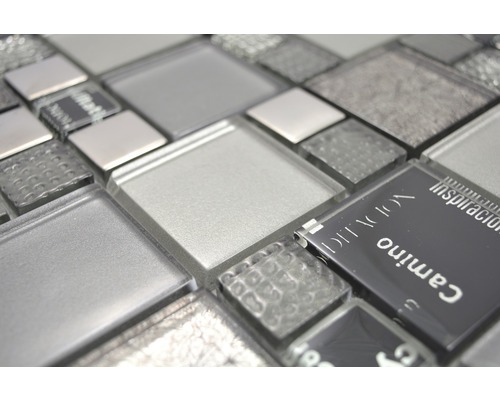 Närbild av glasmosaikplattor i olika gråtoner och texturer.