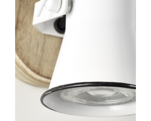 Närbild av en vit vägglampa med träsockel