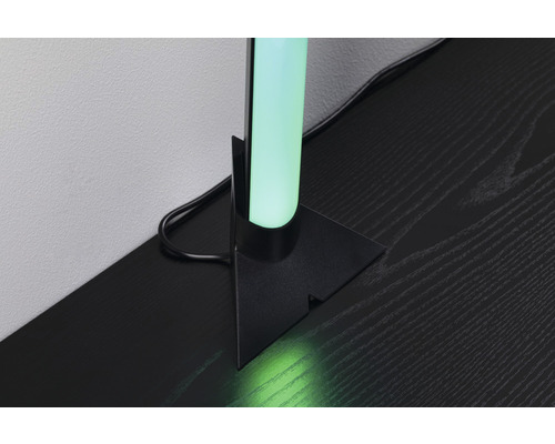 Dekorativ rörformig lampa på en svart träyta