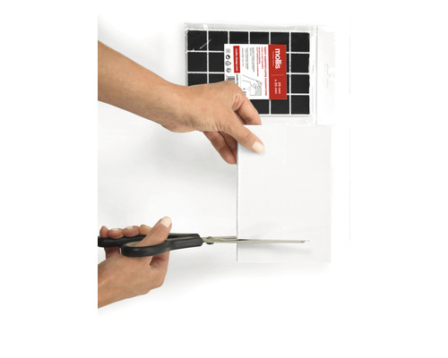 En person klipper en möbeltass med en sax. Möbeltassar för tillskärning syns i bakgrunden.