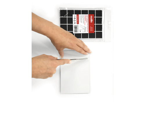 Scen med självhäftande dämpningsplattor som skärs till med en kniv.