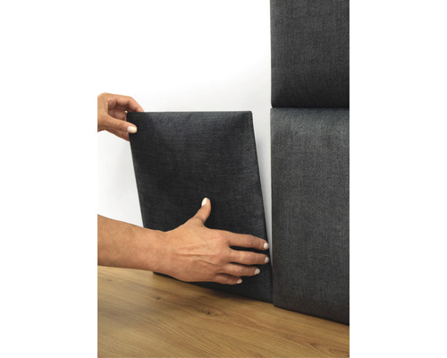 Person monterar akustikpanel på väggen