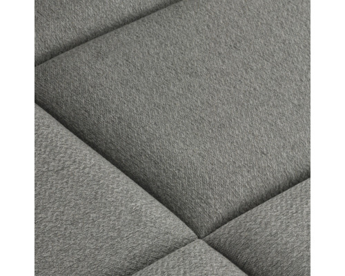 Närbild av en stoppad möbel med tygklädsel och quiltat mönster