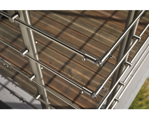 Detaljbild av ett räcke i rostfritt stål på en träterrass