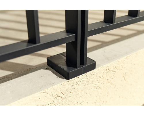 Detaljbild av ett svart metallstaket med markfäste.