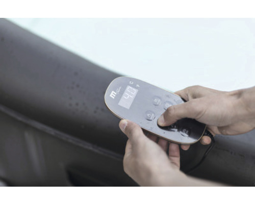 Närbild av en person som använder en fjärrkontroll för en bubbelpool.