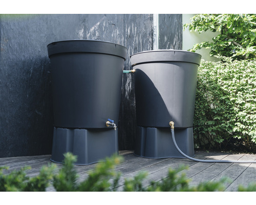 Två regntunnor i plast med kranar och slang på en träaltan