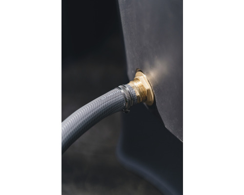 Närbild av en vattentank med ansluten trädgårdsslang