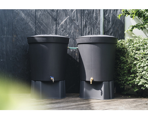 Två regnvattentunnor av plast i trädgården.
