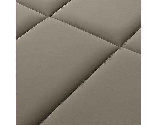 Närbild av en quiltad textilyta med fyrkantiga mönster