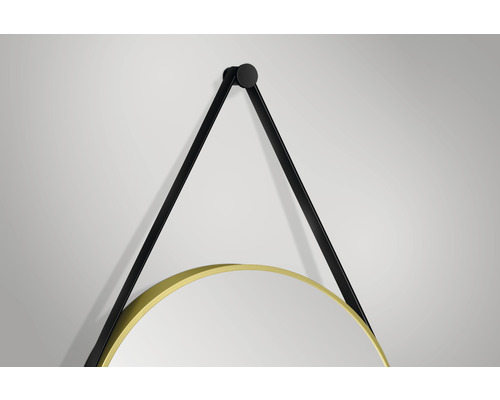 Detaljvy av en rund väggspegel med svart upphängningsrem och guldfärgad ram