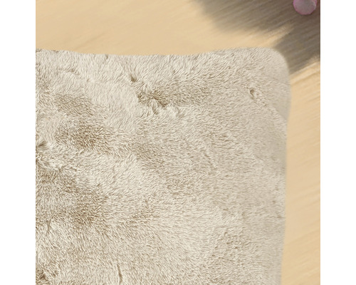 Detalj av en beige, rektangulär ryamatta.