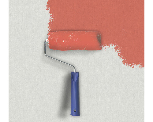 Färgroller med färg på väggen