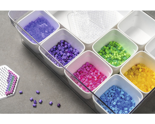 Översikt över ett set med stiftpärlor i olika färger i vita behållare