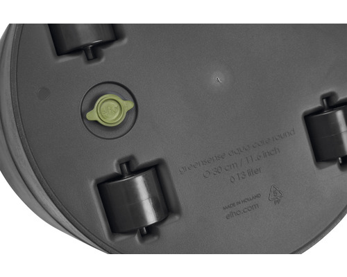 Undersida av en rund blomkruka med hjul, dräneringsplugg och tillverkarinformation