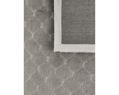 Detaljbild av en matta med geometriskt mönster och kant