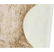 Detaljvy av en beige ryamatta med textilbaksida