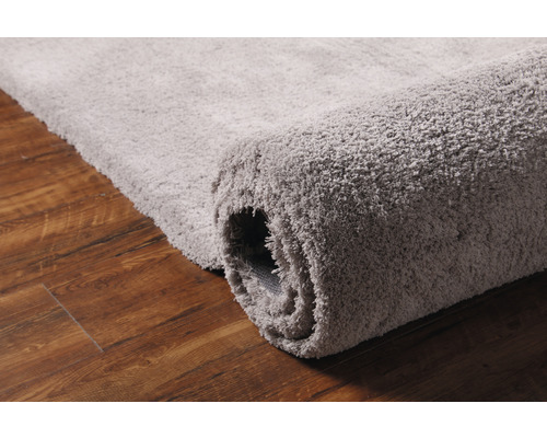 Grå, rullad matta på trägolv