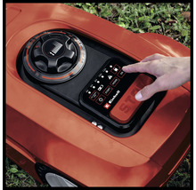 Einhell logotyp. Närbild av en robotgräsklippare med kontrollpanel och hand.