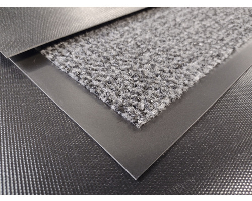 Detaljvy av en dörrmatta med en textilyta och en omgivande kant