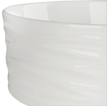 Detaljvy av en vit keramisk skål med en vågig yta